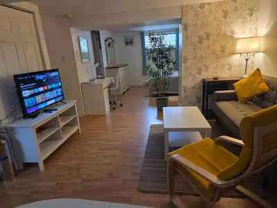 a living room with a couch and a tv at L ' Arlequin Suite et logement in Vaudreuil-Dorion