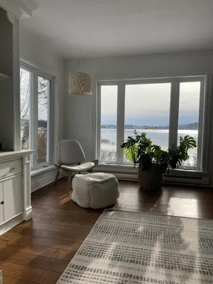 a living room with large windows and a table at Chalet KLS Lac D'Argent in Eastman