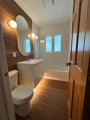 a bathroom with a toilet and a sink and a mirror at Chalet KLS Lac D'Argent in Eastman