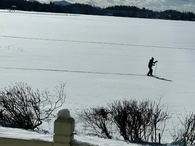 a person cross country skiing across a snow covered field at Chalet KLS Lac D'Argent in Eastman