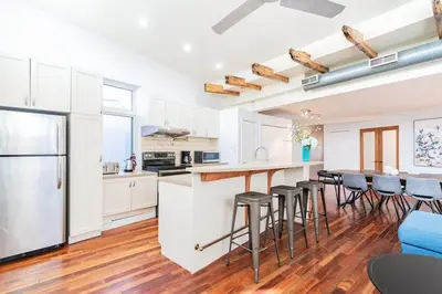 a kitchen with white cabinets and a bar with stools at Luminous and Stylish Renovated Apt in LePlateau in Montréal