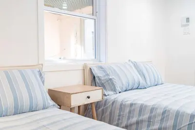 two beds in a room with a table between them at Luminous and Stylish Renovated Apt in LePlateau in Montréal