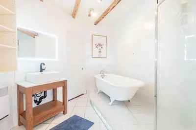 a white bathroom with a tub and a sink at Luminous and Stylish Renovated Apt in LePlateau in Montréal