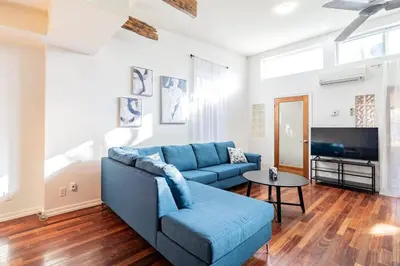 a living room with a blue couch and a table at Luminous and Stylish Renovated Apt in LePlateau in Montréal