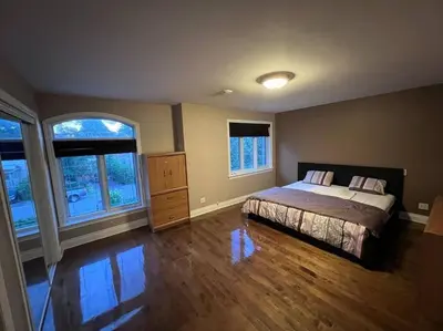 a bedroom with a bed and two windows at Lady Eden Waterfront Mansion - No party in Montréal