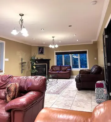 a living room with leather furniture and a fireplace at Lady Eden Waterfront Mansion - No party in Montréal