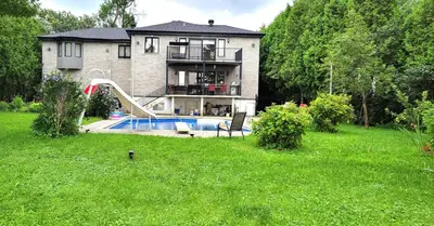 a house with a pool and a slide in the yard at Lady Eden Waterfront Mansion - No party in Montréal