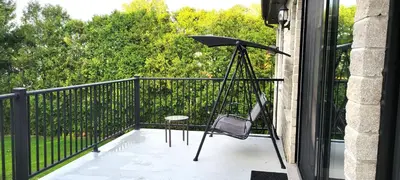 a balcony with a chair and an umbrella at Lady Eden Waterfront Mansion - No party in Montréal