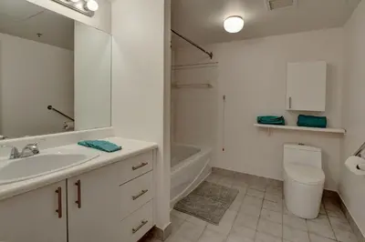 a white bathroom with a sink and a toilet at Laval stays 31 days minimum in Laval