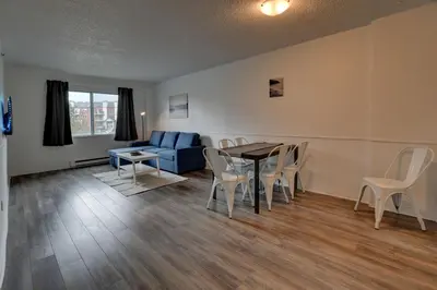 a living room with a table and chairs and a couch at Laval stays 31 days minimum in Laval