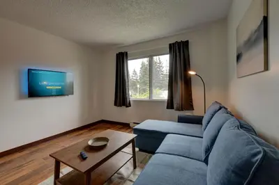 a living room with a blue couch and a table at Laval stays 31 days minimum in Laval