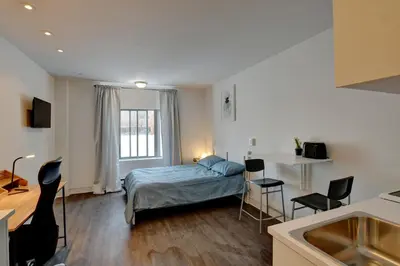 a bedroom with a bed and a table and chairs at Laval stays 31 days minimum in Laval