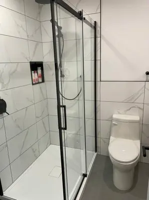 a bathroom with a toilet and a glass shower at Bromont Lodge in Bromont