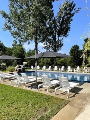 a group of chairs and umbrellas next to a pool at Bromont Lodge in Bromont