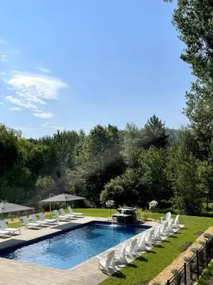 a swimming pool with white chairs and a group ofitures at Bromont Lodge in Bromont