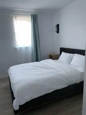 a bedroom with a large white bed with a window at Bromont Lodge in Bromont