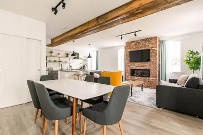 a dining room and living room with a table and chairs at Bromont Lodge in Bromont