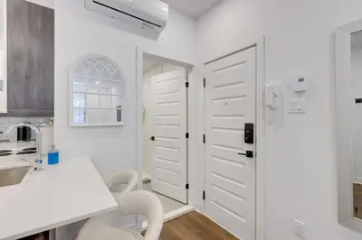 a kitchen with white cabinets and a white door at Le Mile End by M11 - Upscale Studio with Queen Bed in Montréal