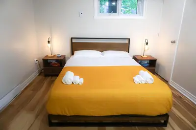 a bedroom with a large yellow bed with towels on it at Cozy apartment in Ahuntsic with Free Parking and near metro station in Montréal