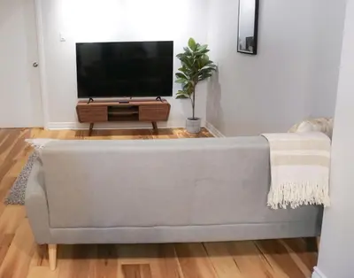 a living room with a couch and a flat screen tv at Cozy apartment in Ahuntsic with Free Parking and near metro station in Montréal