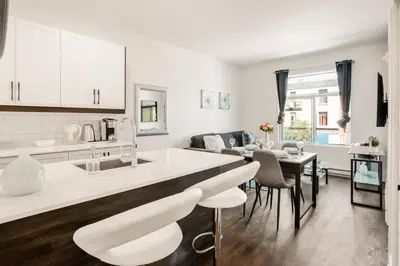 a kitchen and living room with a table and chairs at Le Mile End by M11 - Modern 1 BDR Unit with Sofa Bed in Montréal