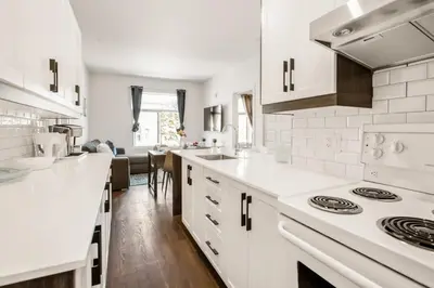 a kitchen with white counters and a stove top oven at Le Mile End by M11 - Modern 1 BDR Unit with Sofa Bed in Montréal