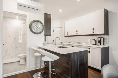 a kitchen with white cabinets and a sink and a clock at Le Mile End by M11 - Modern 1 BDR Unit with Sofa Bed in Montréal