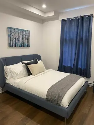 a bed in a room with a blue curtain at Le Mile End by M11 - Upscale Comfy Studio in Montréal