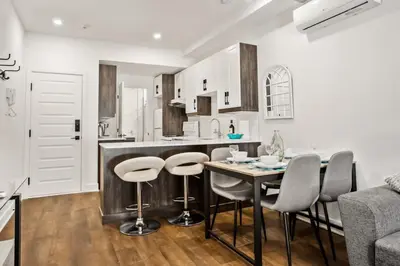 a kitchen with a table and stools in a room at Le Mile End by M11 - Upscale Comfy Studio in Montréal