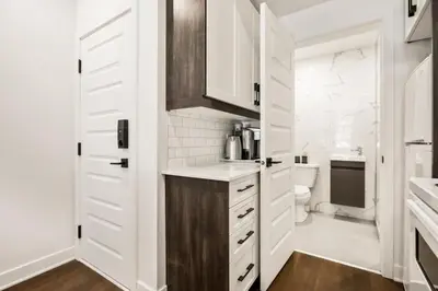 a white kitchen with a sink and a toilet at Le Mile End by M11 - Upscale Comfy Studio in Montréal