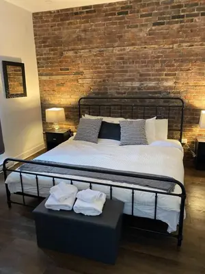 a bedroom with a large bed with a brick wall at Le Mile End by M11 - Upscale 1 BDR with Sofa Bed in Montréal