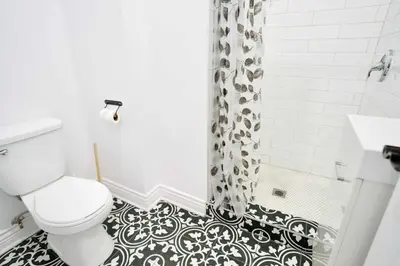 a black and white bathroom with a toilet and a shower at Le Mile End by M11 - Modern Studio in Montréal