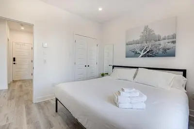 a bedroom with a large white bed with towels on it at Le Mile End by M11 - Upscale & Spacious 1BDR with King Bed in Montréal