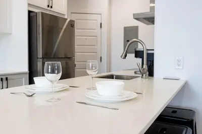 a kitchen with two glasses and plates and a sink at Le Mile End by M11 - Upscale & Spacious 1BDR with King Bed in Montréal