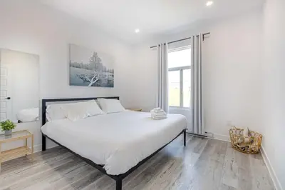 a bedroom with a large bed with white sheets at Le Mile End by M11 - Upscale & Spacious 1BDR with King Bed in Montréal