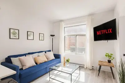 a living room with a blue couch and a window at Le Mile End by M11 - Modern 2BDR with Sofa Bed in Montréal