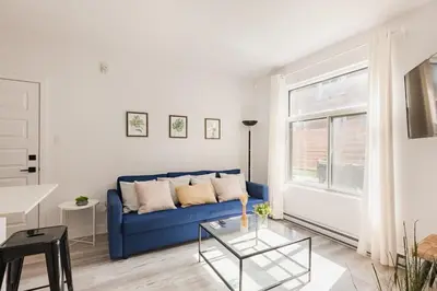 a living room with a blue couch and a table at Le Mile End by M11 - Modern 2BDR with Sofa Bed in Montréal