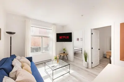 a living room with a blue couch and a window at Le Mile End by M11 - Modern 2BDR with Sofa Bed in Montréal