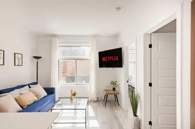 a living room with a blue couch and a window at Le Mile End by M11 - Spacious 2BDR Unit with Sofa Bed in Montréal
