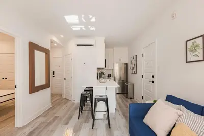 a kitchen and living room with a blue couch at Le Mile End by M11 - Spacious 2BDR Unit with Sofa Bed in Montréal