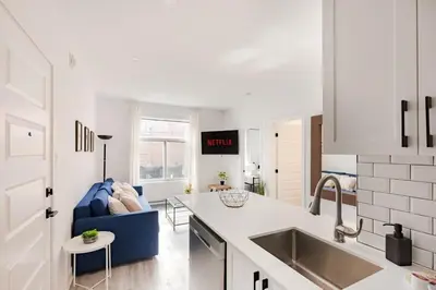 a kitchen with a sink and a blue couch in a kitchen at Le Mile End by M11 - Spacious 2BDR Unit with Sofa Bed in Montréal