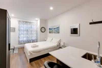 a white room with a bed and a sink at Le Mile End by M11 - Modern & Comfy Studio in Montréal