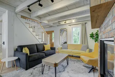a living room with a couch and a table at Maison ancestrale complètement rénovée 4 chambres in Bromont