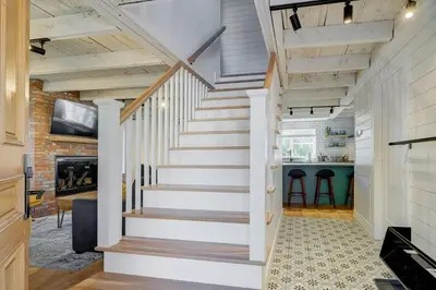 a staircase in a home with white walls and wooden ceilings at Maison ancestrale complètement rénovée 4 chambres in Bromont