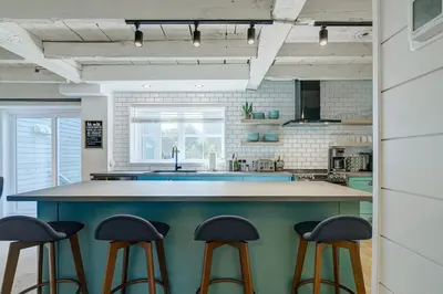 a kitchen with a blue island with stools at Maison ancestrale complètement rénovée 4 chambres in Bromont