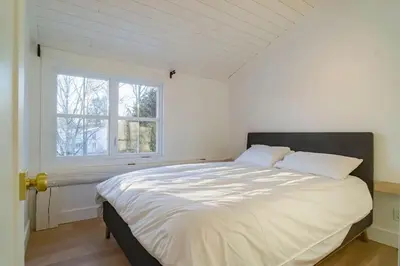 a bedroom with a large bed with a window at Maison 3 chambres à coucher vue sur la montagne in Bromont