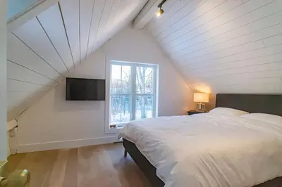 a bedroom with a large bed and a window at Maison 3 chambres à coucher vue sur la montagne in Bromont