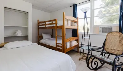 a bedroom with a bunk bed and a chair at Villa de Brome in Lac-Brome