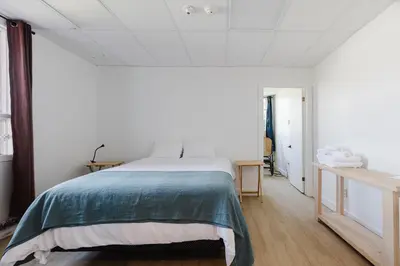 a bedroom with a bed with a green blanket at Villa de Brome in Lac-Brome
