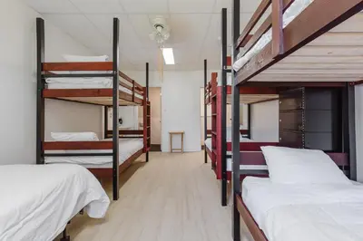 a room with three bunk beds and a hallway at Villa de Brome in Lac-Brome